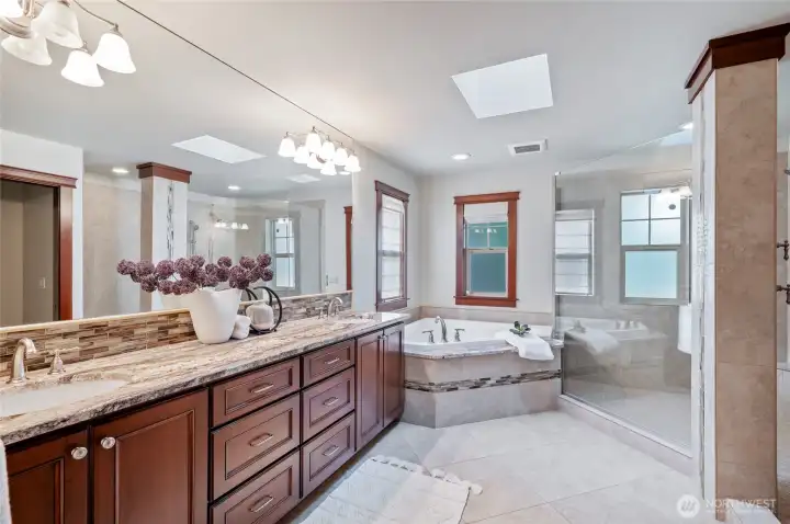 Spa-like bath with spacious vanity with dual sinks, soaking tub, huge doorless step in shower