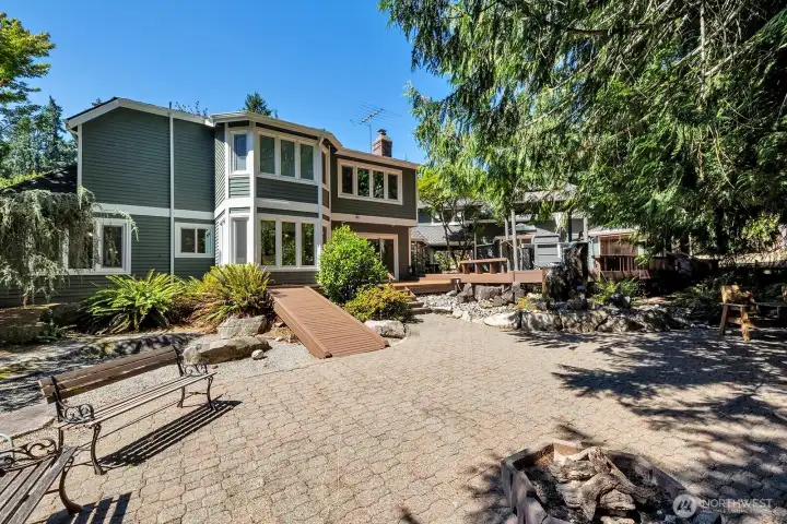 View of the main house from the back yard which features a fountain and gas fire pit .