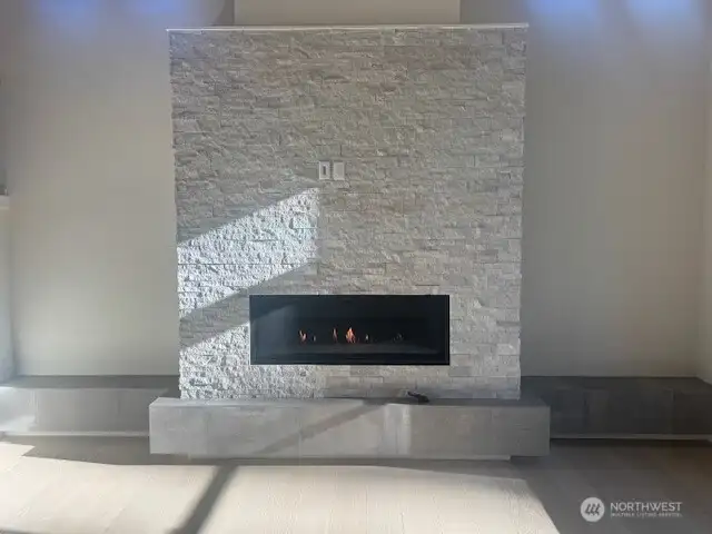 linear gas fireplace with stone facade and raised tile hearth
