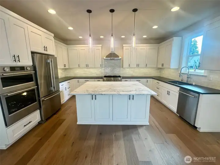 Abundant custom cabinets.   Perimeter counters have a unique leather textured quartz counters.