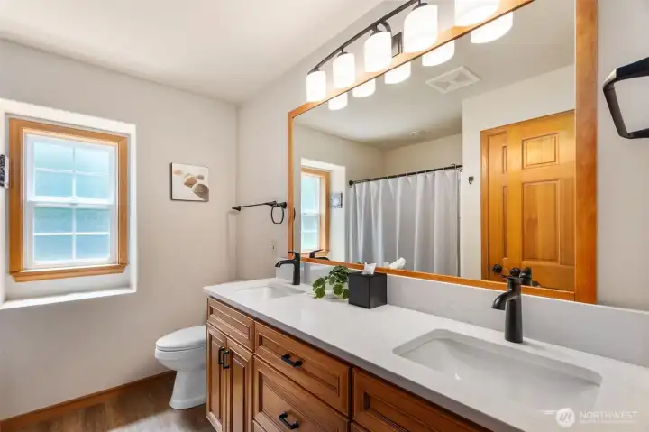 Main floor full bath has updated quartz counters, undermount sinks and hardware. Newly refinished bath tub too!