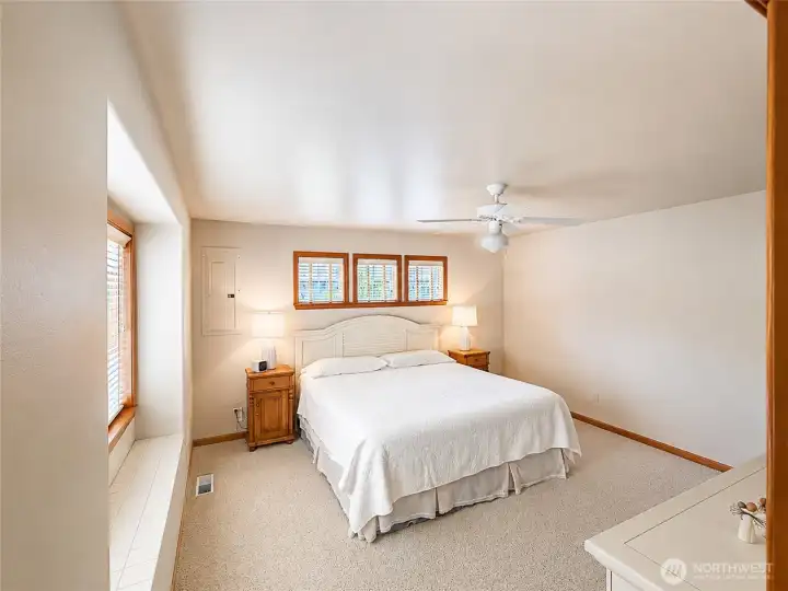 Bright main floor primary from another angle shows the great wall space AND windows in this room