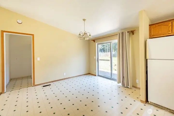Kitchen dining area with laundryroom entrance and sliding door to back yard.