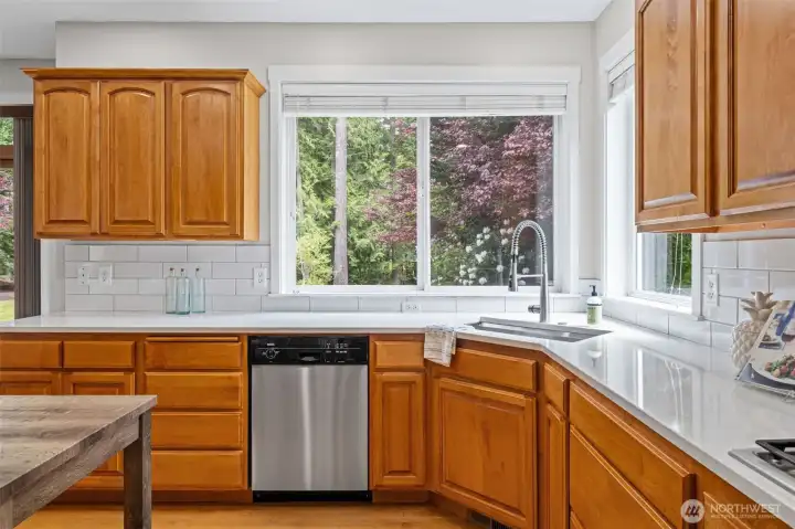 Kitchen window overlooks the spacious backyard and deck