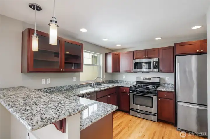 Kitchen with granite slab countertops.  New gas cooking range in 2025