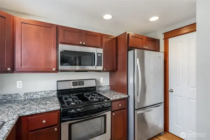Walk-in pantry.  Kitchen with granite slab countertops.  New gas cooking range in 2025