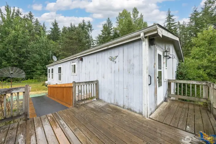 There is a fairly new wheelchair ramp and a nice deck. The home home and lawn is surrounded by evergreens.