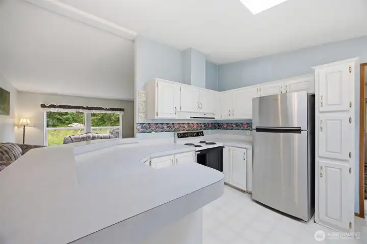 The kitchen has a large eating bar and is open to the living room.