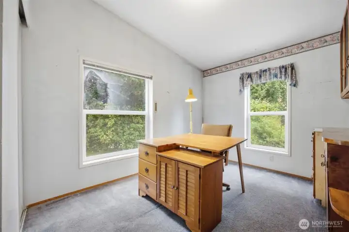 The third bedroom is a corner room and looks out to the towering evergreens.