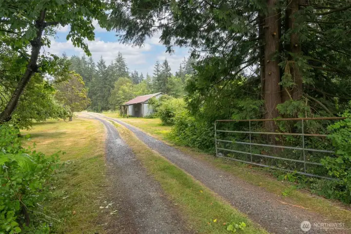 The driveway has a gate and a long circular driveway.
