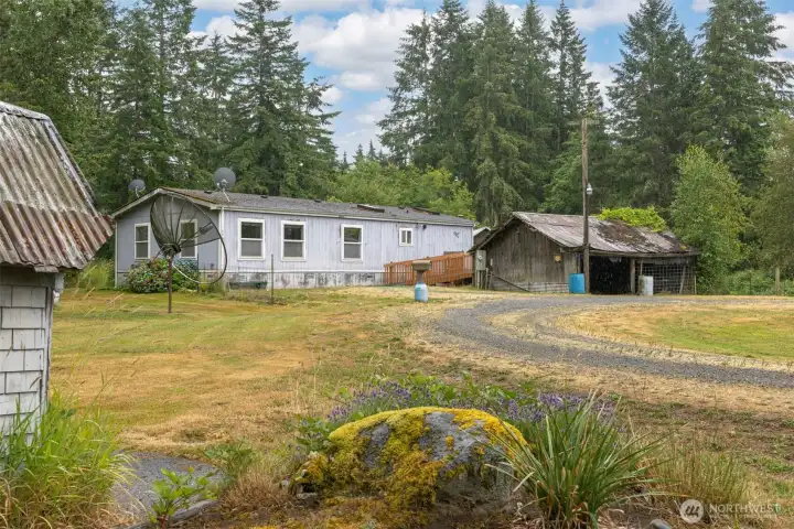 Looking at the home with the detached 2 vehicle garage and the well pumphouse (to the left).