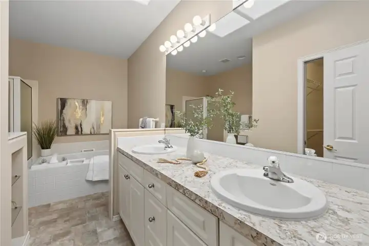 Primary bath with double vanities and a soaking tub with separate shower.