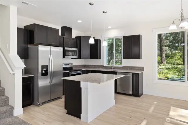 Stainless steel appliances to include microwave as well as dishwasher to the right of the kitchen sink.