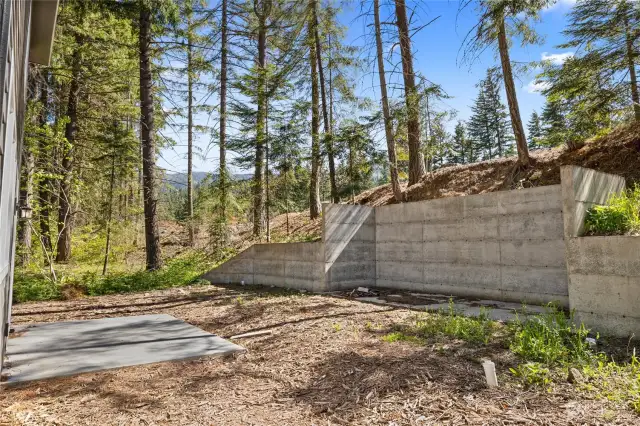 Backyard just waiting to be completed into your entertainment dream of an area.  Sturdy retaining wall already in place as well as cement patio.