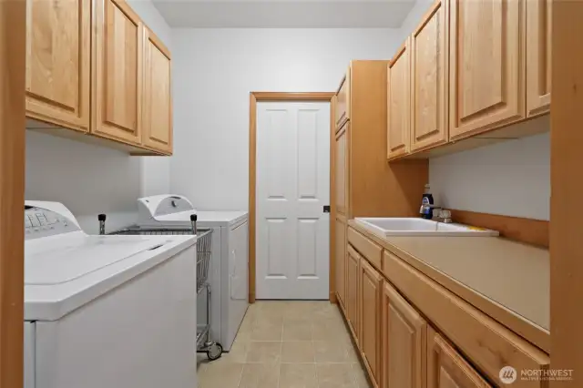 Large laundry room with tons of storage and a sink!