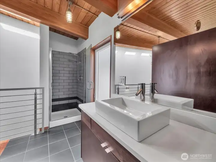 En suite bathroom w/ luxurious shower & frosted window, letting in lots of light, while maintainig privacy.