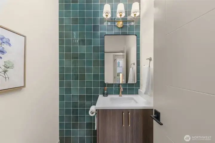 Stylish powder bathroom featuring designer tile work and modern fixtures.
