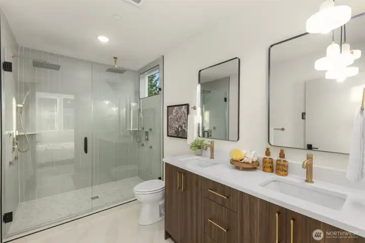 Luxurious primary bathroom boasting a double vanity, contemporary fixtures, and a glass-enclosed shower.