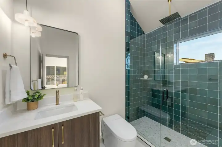 Stylish full bathroom featuring vibrant teal designer tile and a modern floating vanity.
