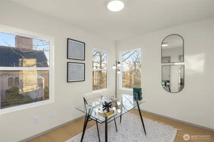 Bright and versatile bonus room with large windows, ideal for a home office or creative studio.