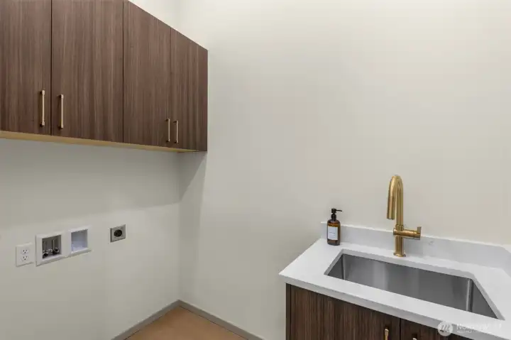 Convenient utility space with contemporary cabinetry and a deep soaking sink.