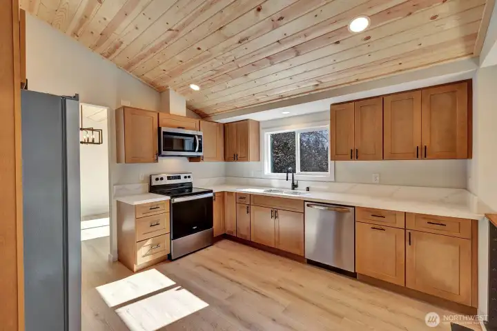 Brand new kitchen boasts new cabinets, quartz counters and stainless steel appliances.