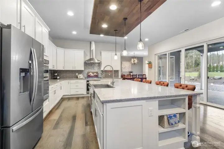 Another view of the amazing kitchen. A wall of windows across the rear of the home, including a large sliding door to the patio, fills the kitchen, dining, and living areas with natural light while offering views of the backyard.