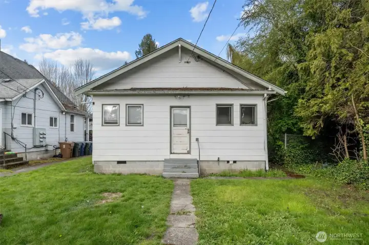 Back view of home, door leads to laundry room/utility room.
