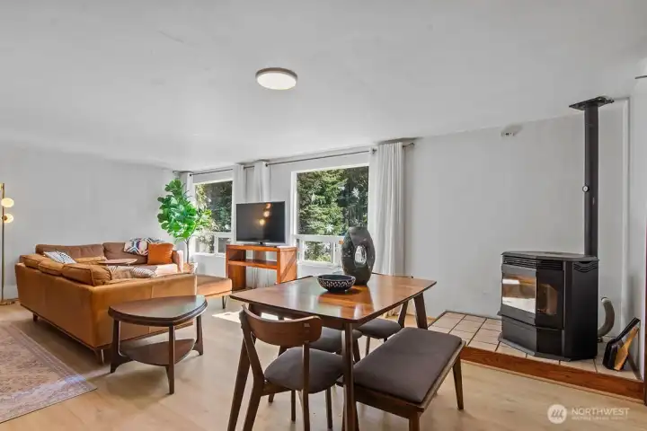 Main living room area with wood stove as well as the sliding door to the back deck