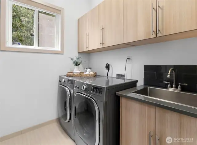 Efficient laundry room with ample cabinetry and storage.