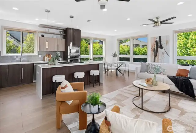 Open-concept living flows to kitchen and dining—lush landscaping provides privacy.