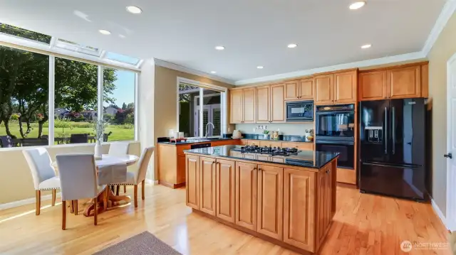 Sky-wall of windows highlight the kitchen and eating nook with serene views of the golf course