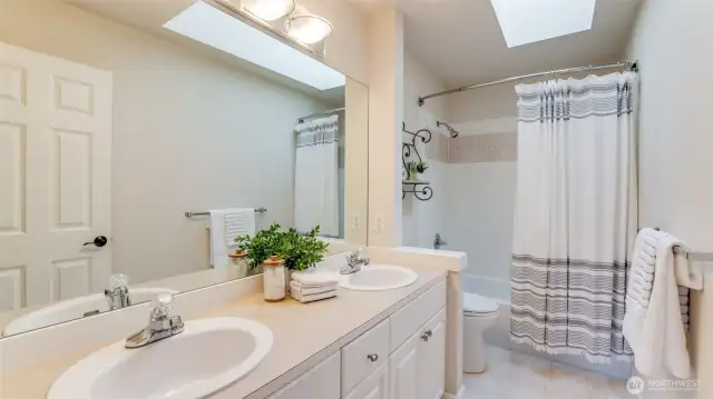 Full bath with skylight services secondary bedrooms