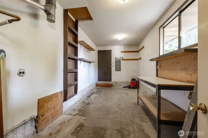 And through the garage, there is a separate workshop with workbench and door leading to the outside. Big windows let in the light.