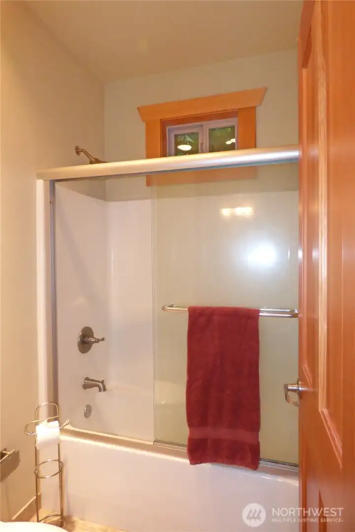 Bathtub and toilet with door between this area and the sink.
