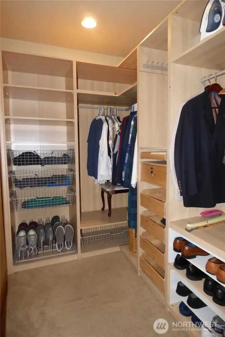 Primary closet #2 with built-in drawers and shelving.