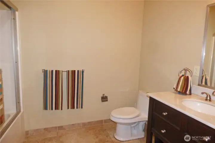 Downstairs, full bathroom with tiled floors.