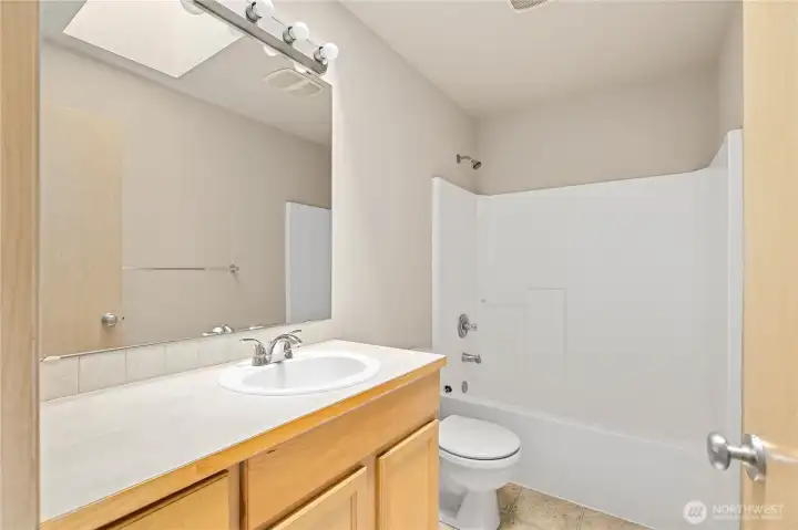 Full size hall bathroom with lots of light from the skylight.