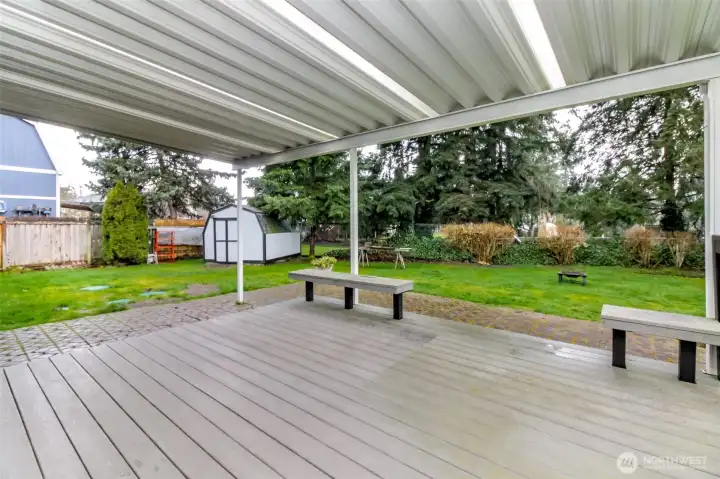 Beautifully done covered composite deck with built in benches.  Patio frames the front and left side.