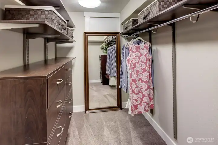 Primary closet with tons of extra storage behind the mirror