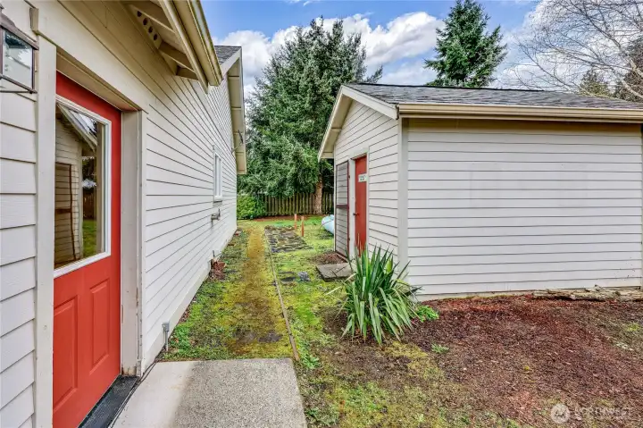 Side door to the garage and large outbuilding