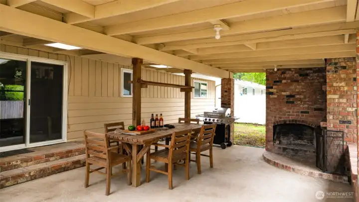 Designed for gathering and unwinding, this expansive covered patio creates an inviting extension of the home’s living space. The rustic wood dining setup, built-in BBQ area, and striking brick fireplace combine to create a warm atmosphere ideal for entertaining in every season. Whether hosting dinner with friends or enjoying a quiet evening by the fire, this outdoor space offers comfort, character, and exceptional versatility.