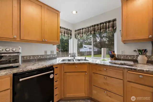 Love the corner set sink to see the lush yard.