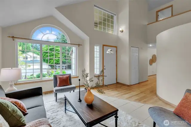 Step in this welcoming and bright living space, featuring high vaulted ceiling and large windows.