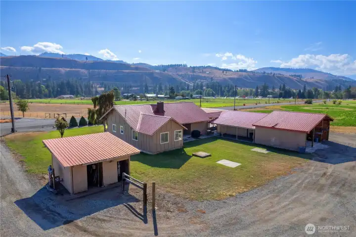 Charming single-level home, and multiple outbuildings, set against a dramatic Methow Valley hillside backdrop.