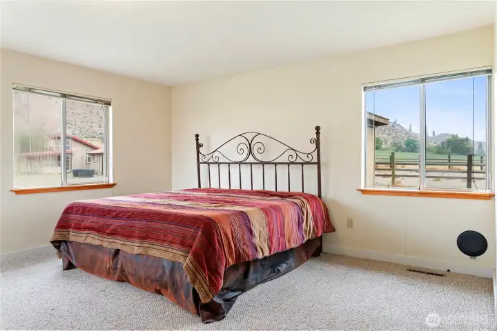 Bright bedroom with double windows and neutral carpet, creating a comfortable and versatile living space.