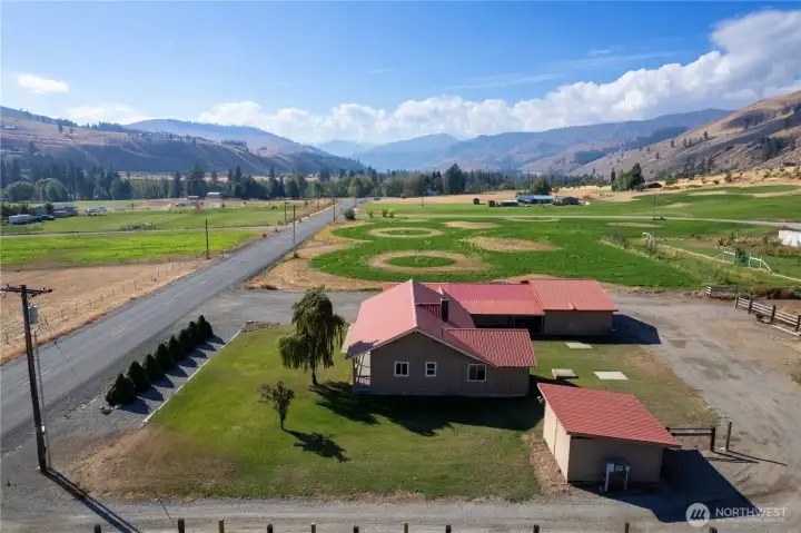 Back property view with open pastures, fencing, and stunning valley and mountain scenery.