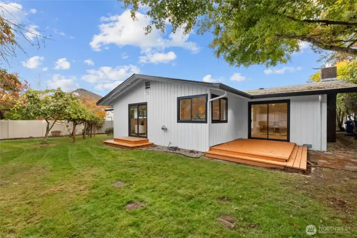 BACKYARD BLISS | Enjoy outdoor living on this deck. Trees have been trimmed to allow light and roof clearance.
