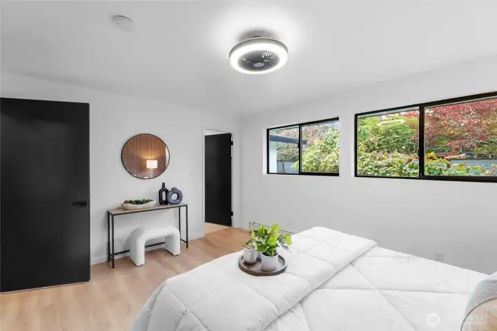 PRIMARY BEDROOM 1 | Another view of this bedroom shows access to a private bathroom. The new window glass allows a stunning outdoor vibe in this space.