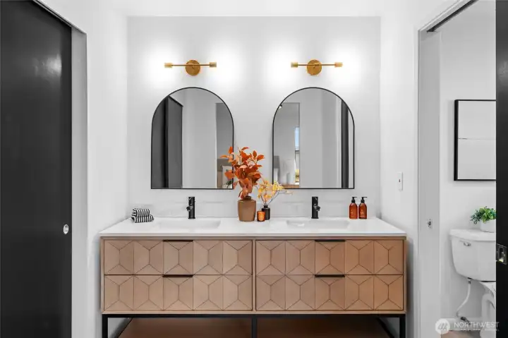PRIMARY BEDROOM 2 BATHROOM | The gorgeous vanity and lights create such a beautiful space to get ready for the day. To the left is the closet and to the right is the shower and toilet with a pocket door for privacy.